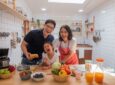 Happy family preparing healthy breakfast menu in white kitchen