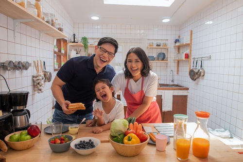 Happy family preparing healthy breakfast menu in white kitchen
