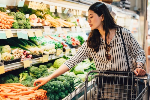 A woman pick some vegetables in a supermarket